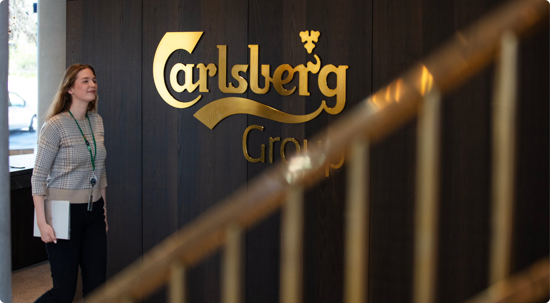 female employee in Carlsberg lobby carrying HP laptop