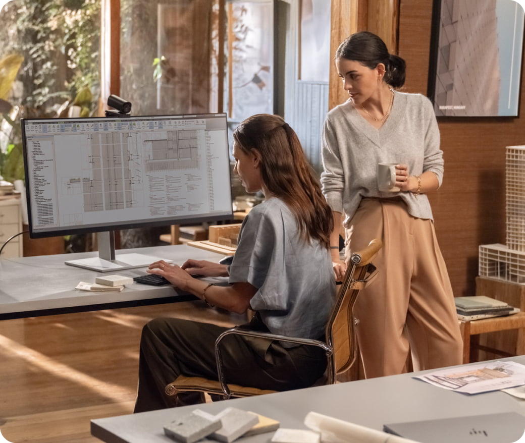 Two female professionals in modern office collaborating at workspace with a HP Z2 Tower G1i Workstation Desktop PC