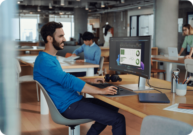A man working in an open workspace with his HP desktop computer.